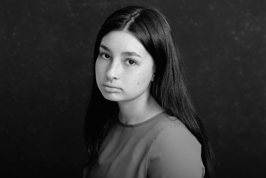 Serious fine art portrait in black and white of teenage girl in Melbourne family portrait studio.